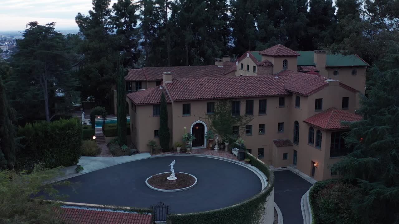 Low close-up aerial panning shot of the ornate Paramour Estate at low light in Hollywood, California. 4K