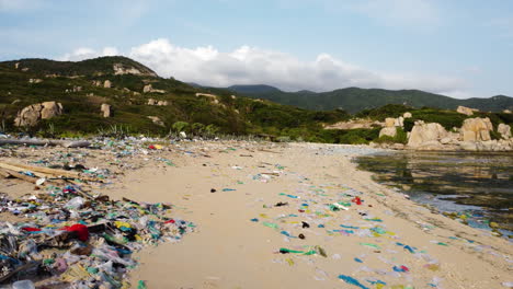 vista aérea de la contaminación del océano en asia, los drones revelan montones de desechos plásticos y basura en una playa tropical de arena en vietnam