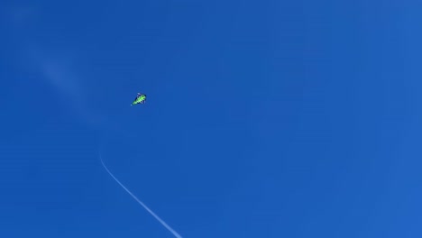 cometa verde con cuerda larga volando en lo profundo