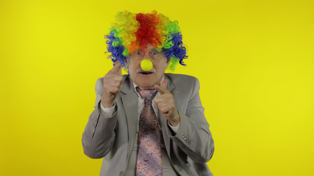 anciano payaso empresario freelancer jefe haciendo señales de tiro de las manos