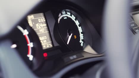 car start and low fuel level symbol showing on dashboard, extreme closeup side view