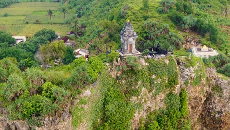 buddhist temple aerial dolly out to reveal cliff and ngobaran beach, indonesia