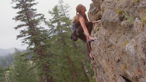 Side-view-of-a-rock-climber-scaling-a-sheer-rock-wall