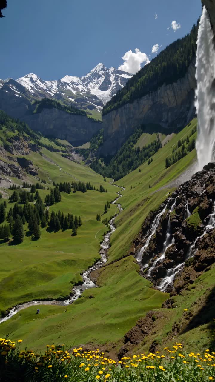 Uno straordinario fotogramma video di una cascata che si riversa in una valle lussureggiante, ripreso da un'angolazione bassa
