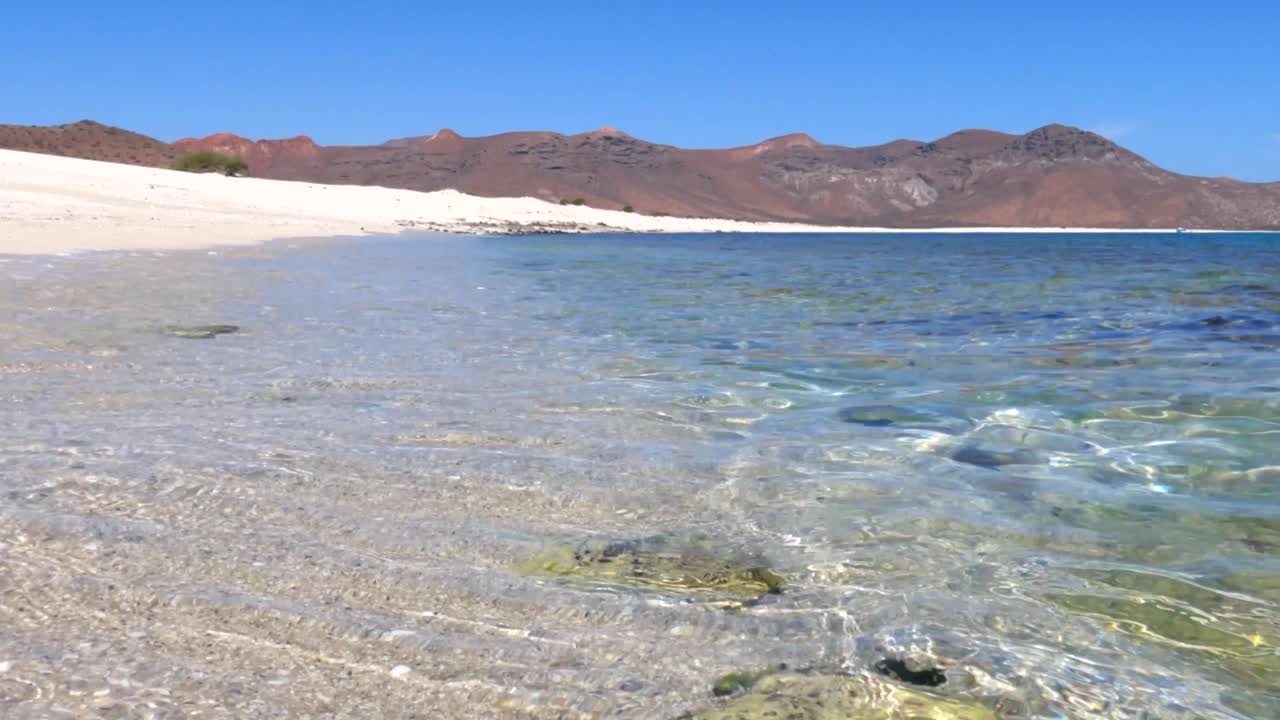 크리스탈처럼 은 바물이 멕시코의 은 날에  모래 해변을 따라 흐르고 있습니다.