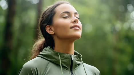 a serene video scene captures a woman in a green jacket, eyes closed, in a forest