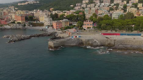 the coastline in genoa, italy with colorful buildings and calm sea, daylight, aerial view