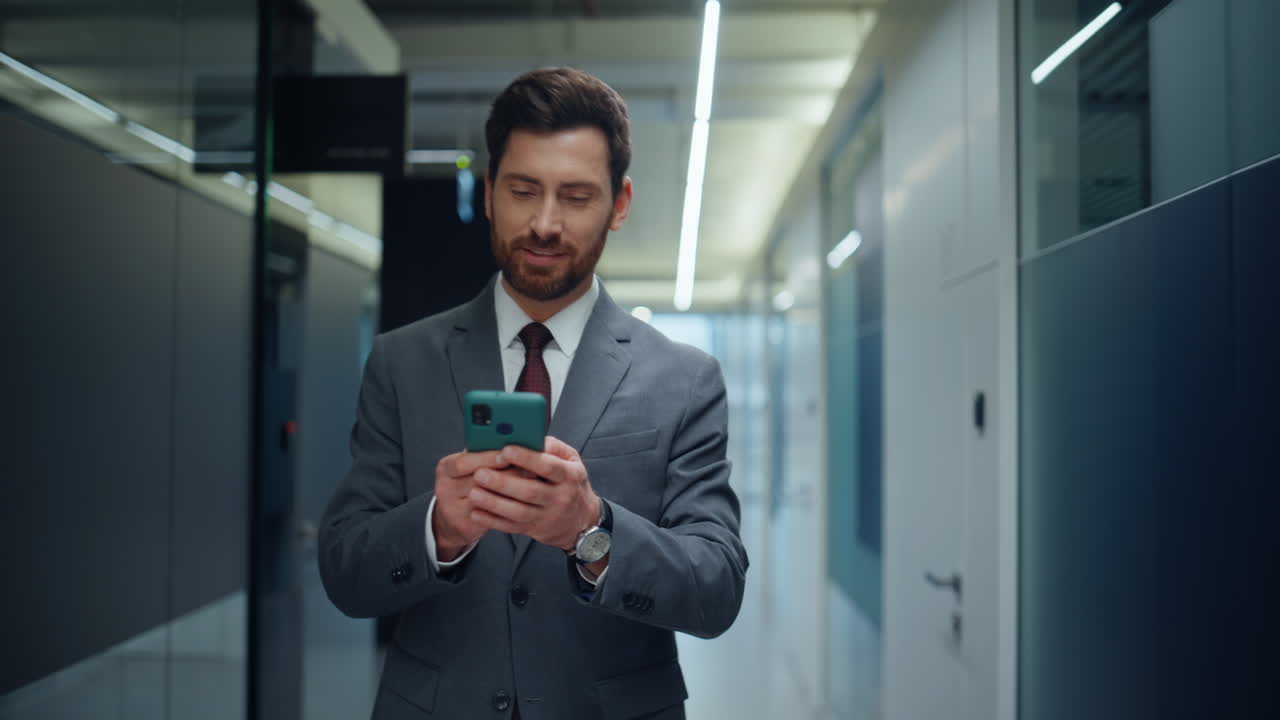 Formal suit director messaging smartphone checking time stepping hall closeup