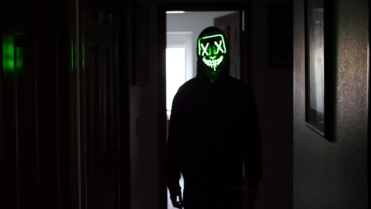 un asesino slasher aterrador y espeluznante con una máscara de terror de halloween persiguiendo a una víctima con un cuchillo