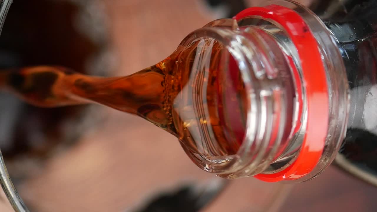 Coca-Cola Pouring into Glass Bottle