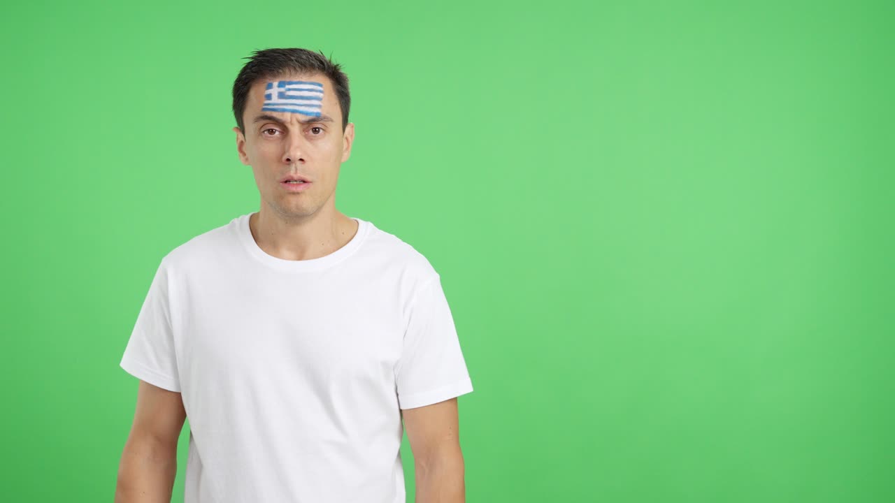 Man standing with greek flag painted on face smiling