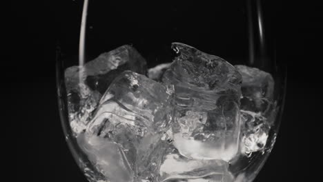 ice cubes falling empty transparent glass closeup. cocktails preparation concept