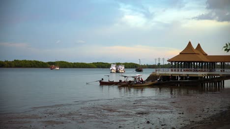 la gente local aborda botes de cola larga para el transporte a un pequeño pueblo en el río pak nam en krabi, tailandia