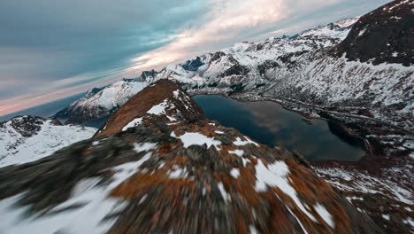 snow-covered mountains at senja island during sunset with dramatic cloudy skies