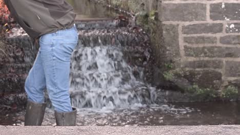 washing wellington boots in a stream