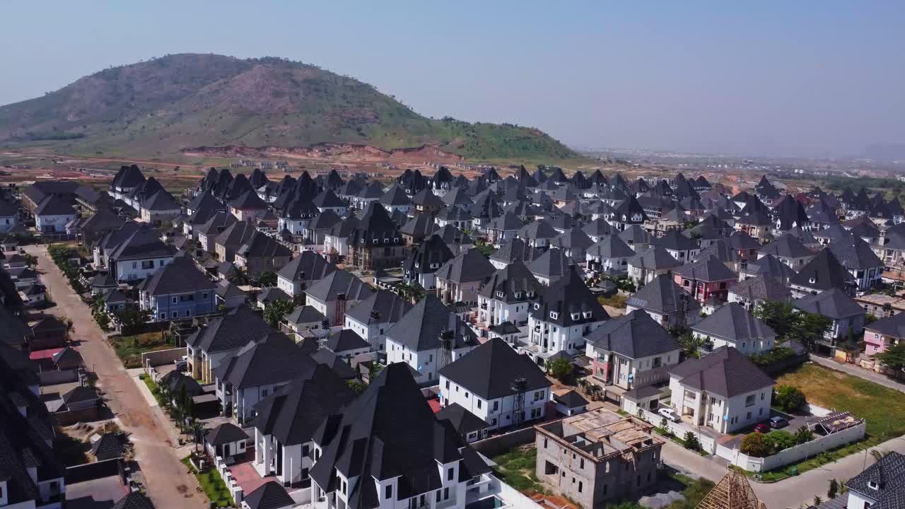 Cảnh đẹp từ trên cao của một khu dân cư ngoại ô rộng lớn và giàu có với những ngôi nhà sang trọng ở Abuja, Nigeria. Những dãy núi cao có thể được nhìn thấy ở phía sau.