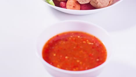 albóndigas fritas y salsa para mojar en un fondo blanco