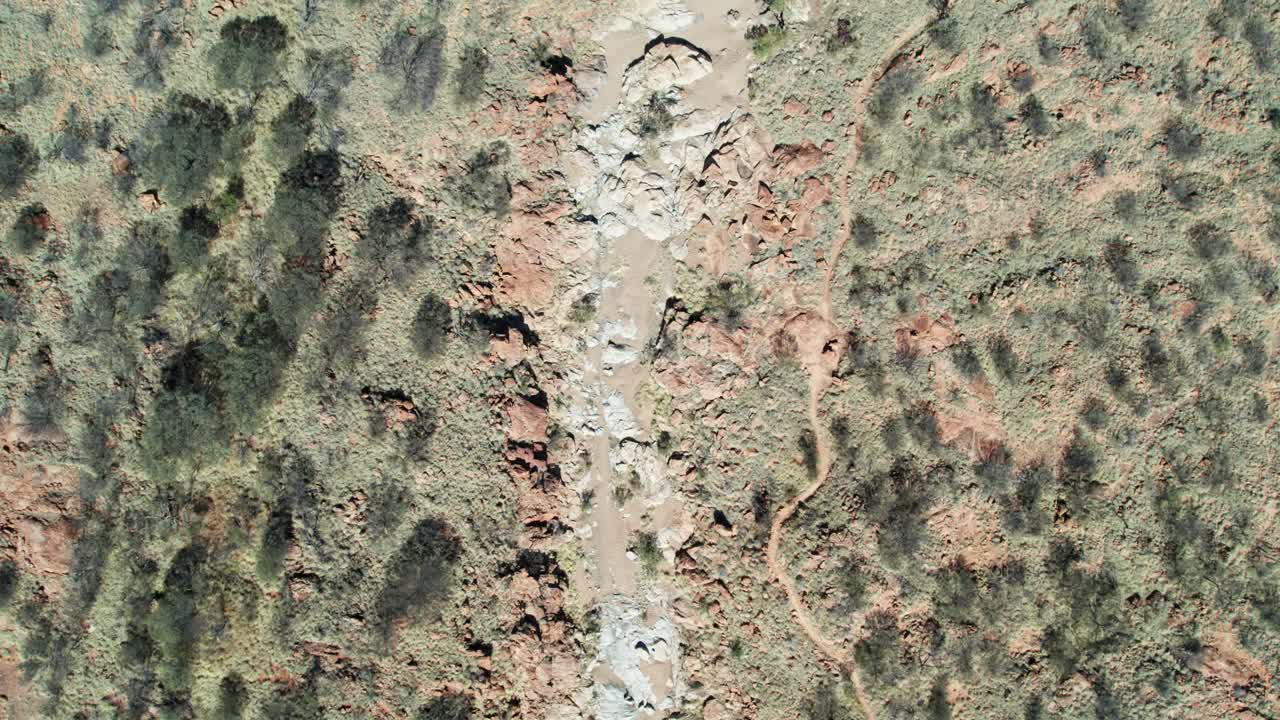 Vertical drone view of the dry and rocky Charles River at Irlpme, a northern suburb of Alice Springs, Mparntwe, Northern Territory, Australia. August 2022.