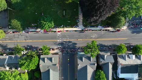 Top-down-aerial-of-people-lining-street,-waiting-for-parade-to-start