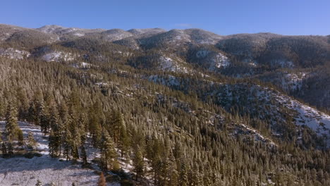 beautiful winter landscape in the mountains of lake tahoe, nevada with a pan over trees and hills on the horizon