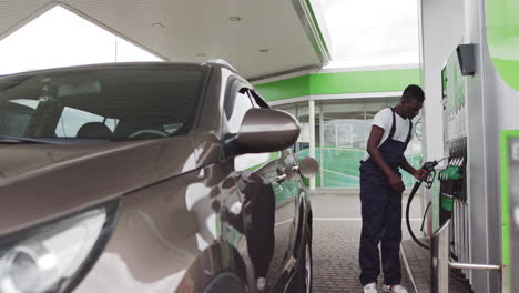 man filling up car at gas station