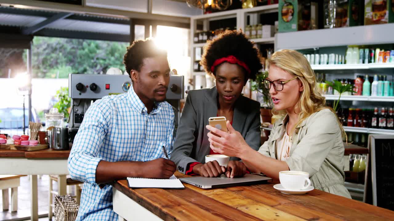 Man and woman interacting with each other while having cup of coffee