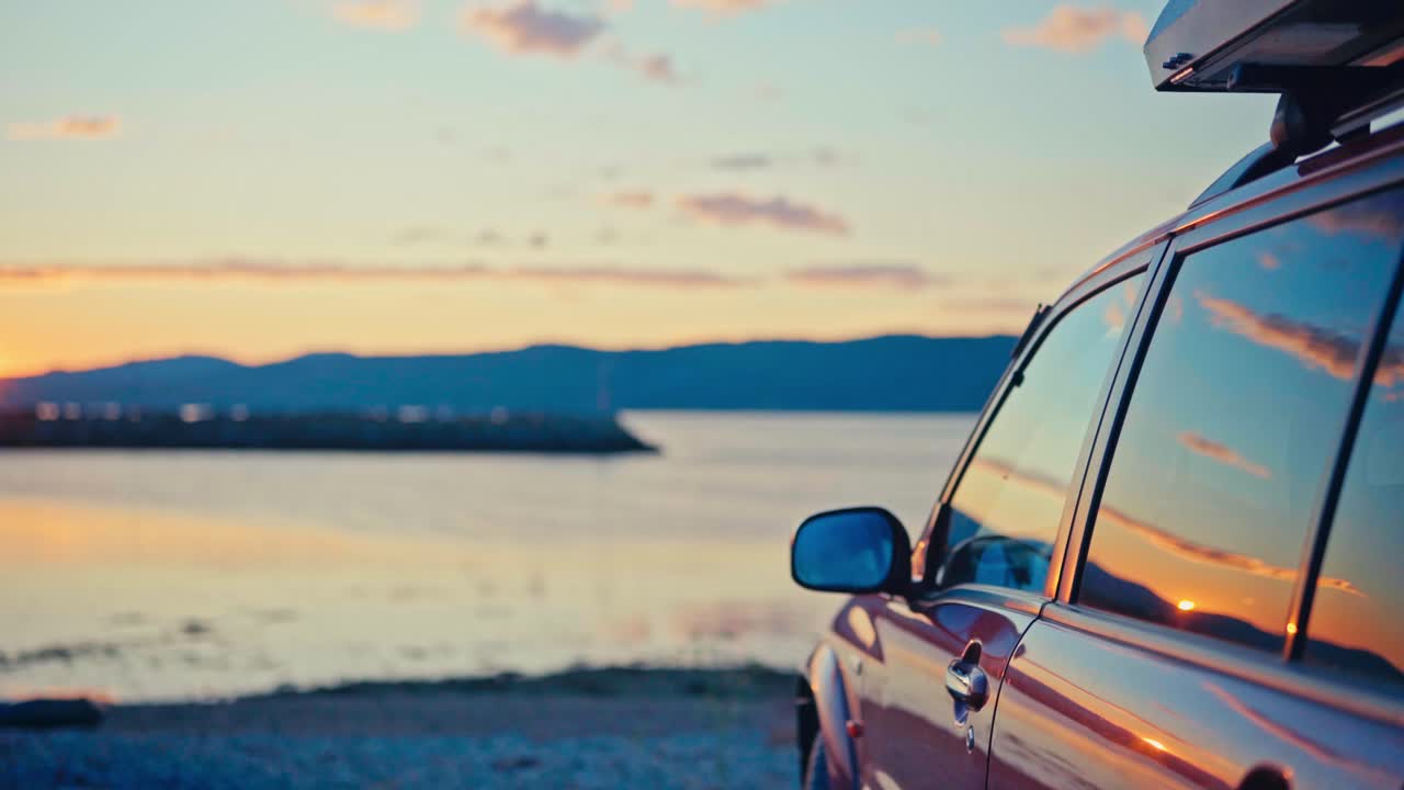 Kokelv, Hammerfest, Finnmark, Norway - As the Sun Sets Over the Tranquil Bay, a Parked Car Reflects the Golden Light and Pastel Skies - Handheld Shot