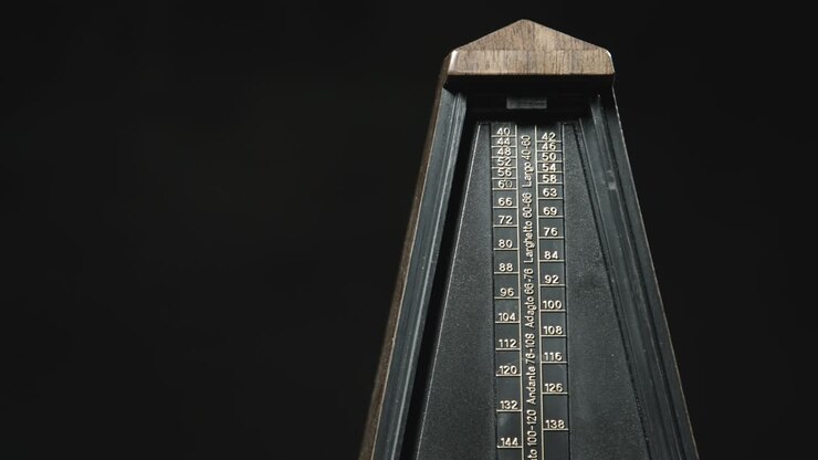 Close-up shot of vintage metronome with golden pendulum