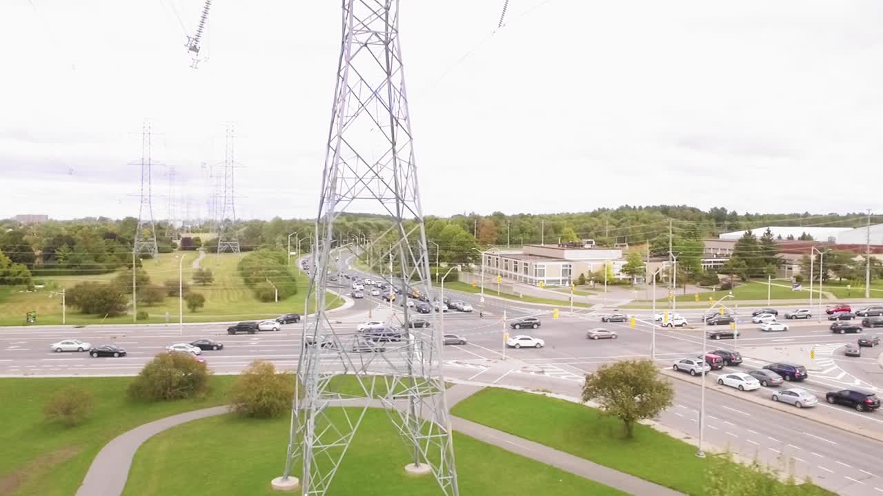 Stunning tracking shot of power stations in front of a busy intersection