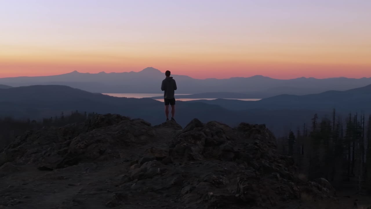 Sunset view with person on mountain captures solitude and reflection