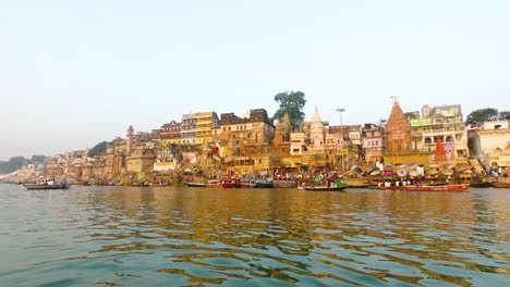 river ganges in varanasi with buildings lit in the morning sunrise in india