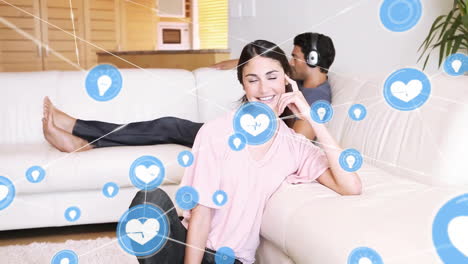 animation of network of connected icons in circles over happy biracial couple listening to music