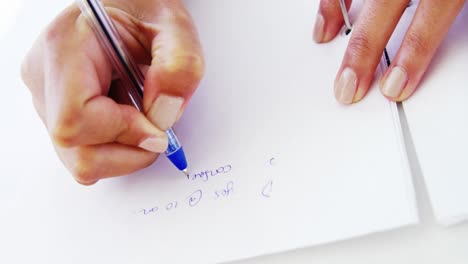 woman taking notes on blank paper