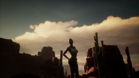 woman in torn shirt standing by cactus in desert at sunset