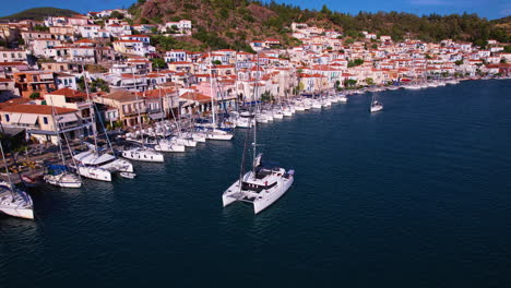 catamaran yacht cruising past a boat village in greece