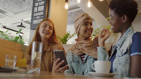 young adult female friends hanging out in a cafe