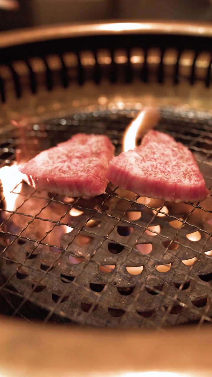 炭火で焼かれる和牛2切れ