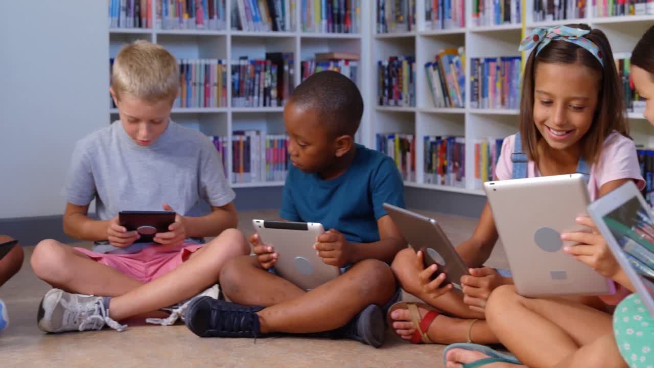 School kids using digital tablet in library