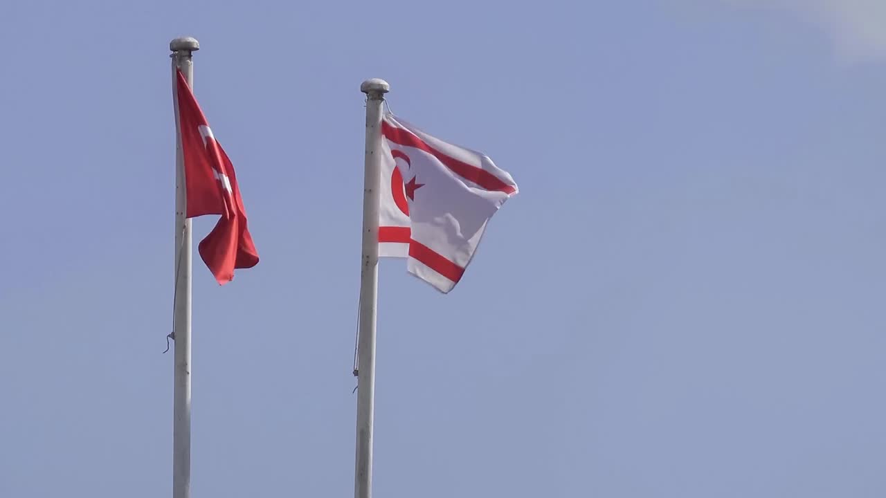 Flags of Turkey and Turkish Republic of Northern Cyprus waving in strong wind, static shot