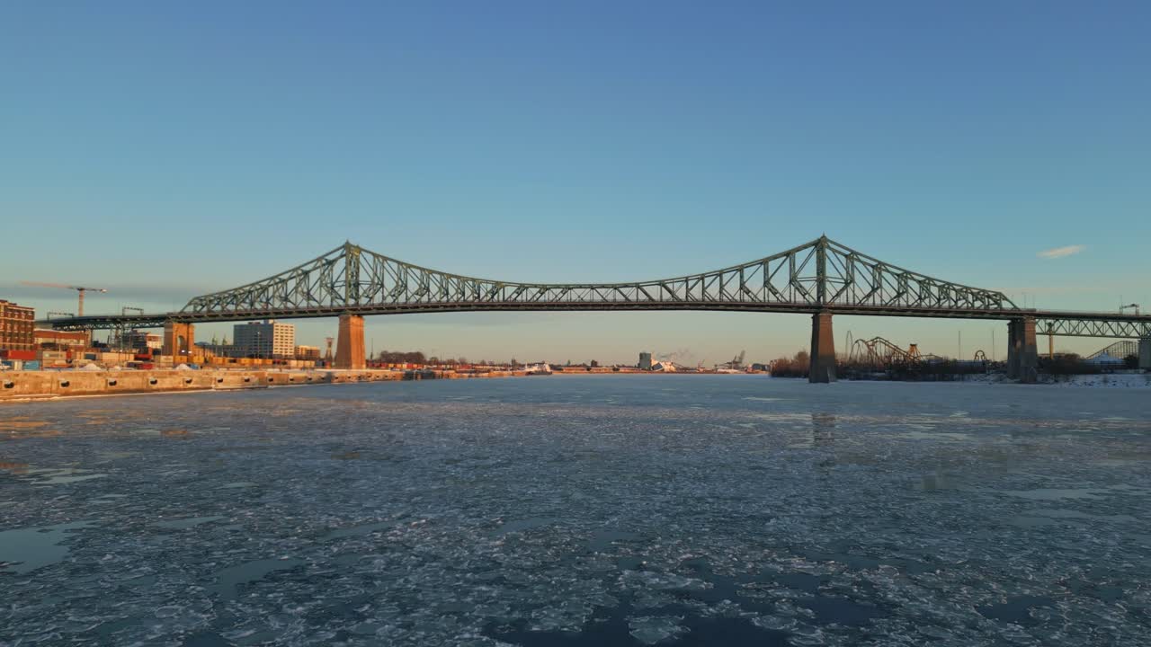 Aerial view of Montreal’s iconic steel bridge spanning over the frozen St. Lawrence River, North America, Quebec, Montreal, Canada.