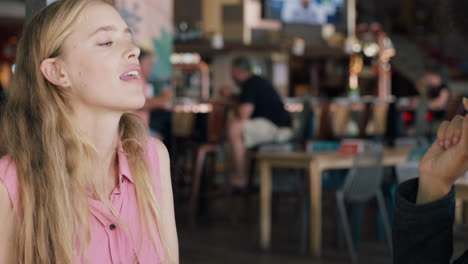 funny-woman-catching-food-in-mouth-best-friends-in-restaurant-playing-game-having-friend-throwing-french-fries-two-women-hanging-out-having-fun