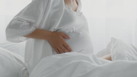 妊娠中の女性がベッドに横たわっています