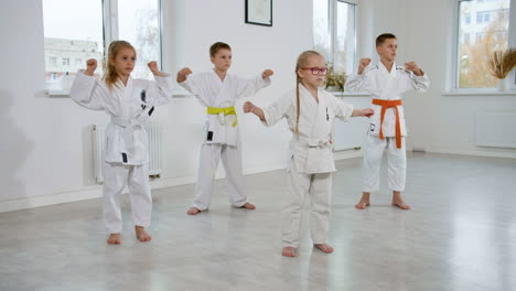 niños en kimono blanco en la clase de artes marciales