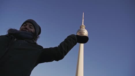 Mädchen-Posiert-Für-Ein-Foto-Mit-Kugel-Auf-Dem-Berliner-Fernsehturm,-Aufnahme-Aus-Niedrigem-Winkel