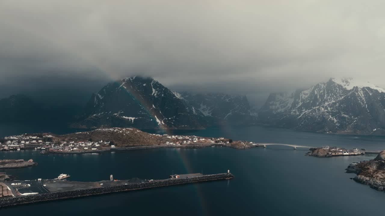 Rainbow In The Coast Of Reine Village In Winter In Norway. - aerial shot