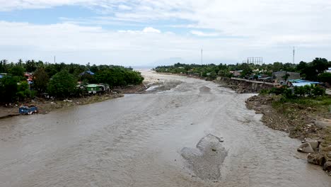 a large muddy river and damage on environment caused by extreme weather and flash flood hitting the country overnight, comoro river in capital dili, timor leste, southeast asia