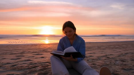 woman reading book on beach at sunset