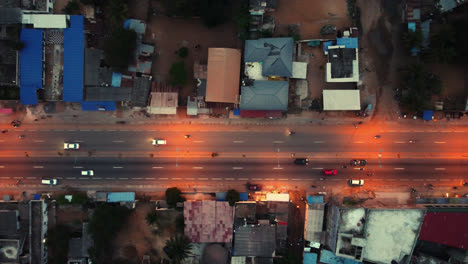 cinematic 4k travelling top down aerial drone shot of road traffic at night with cars driving during rush hour in african city - lomé, africa