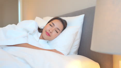 pan close up of a woman taking a nap on a luxurious hotel bed