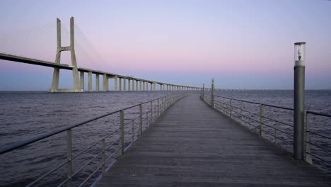 puente vasco da gama vista desde un muelle al atardecer
